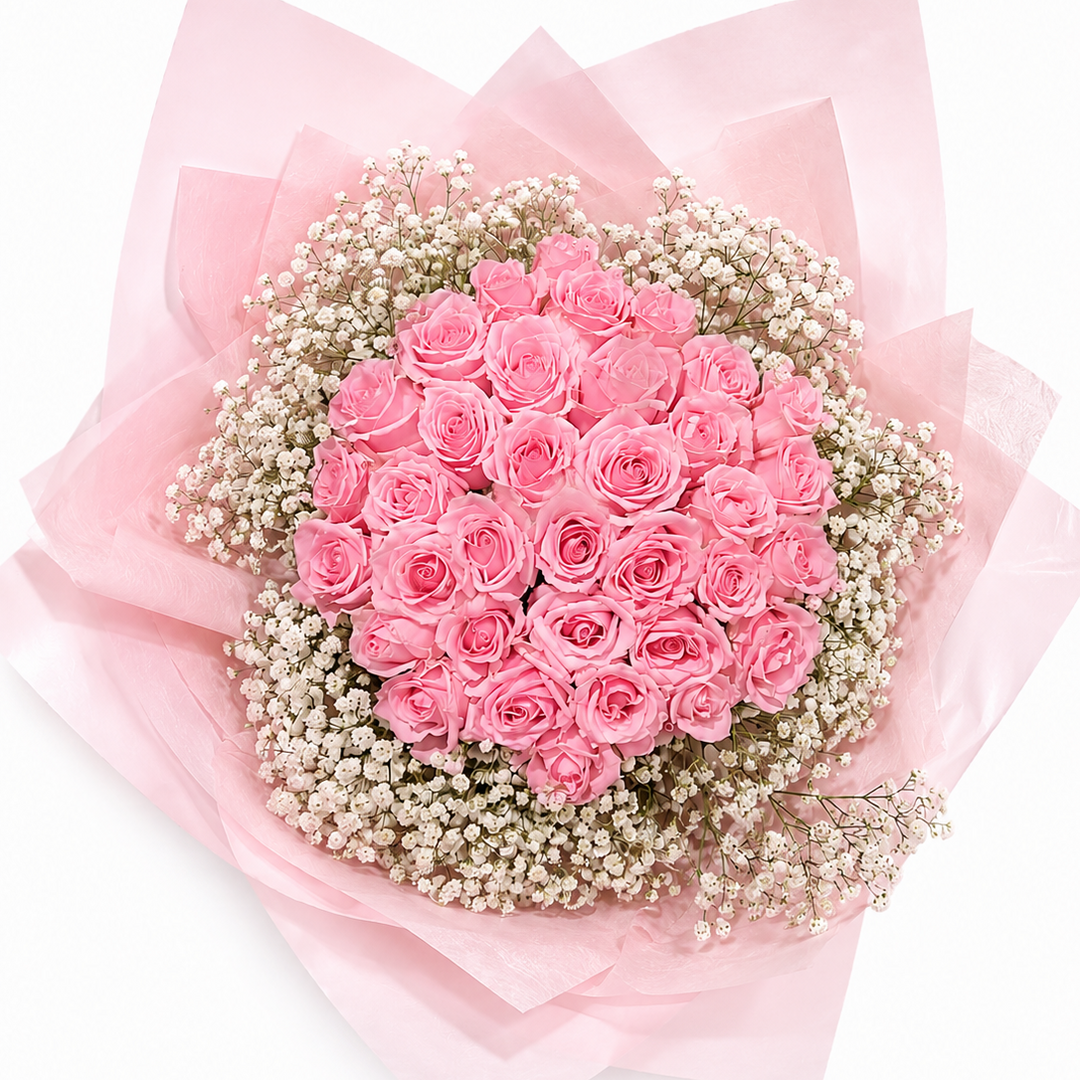 Bouquet of pink roses with baby's breath wrapped in pink paper on a white background