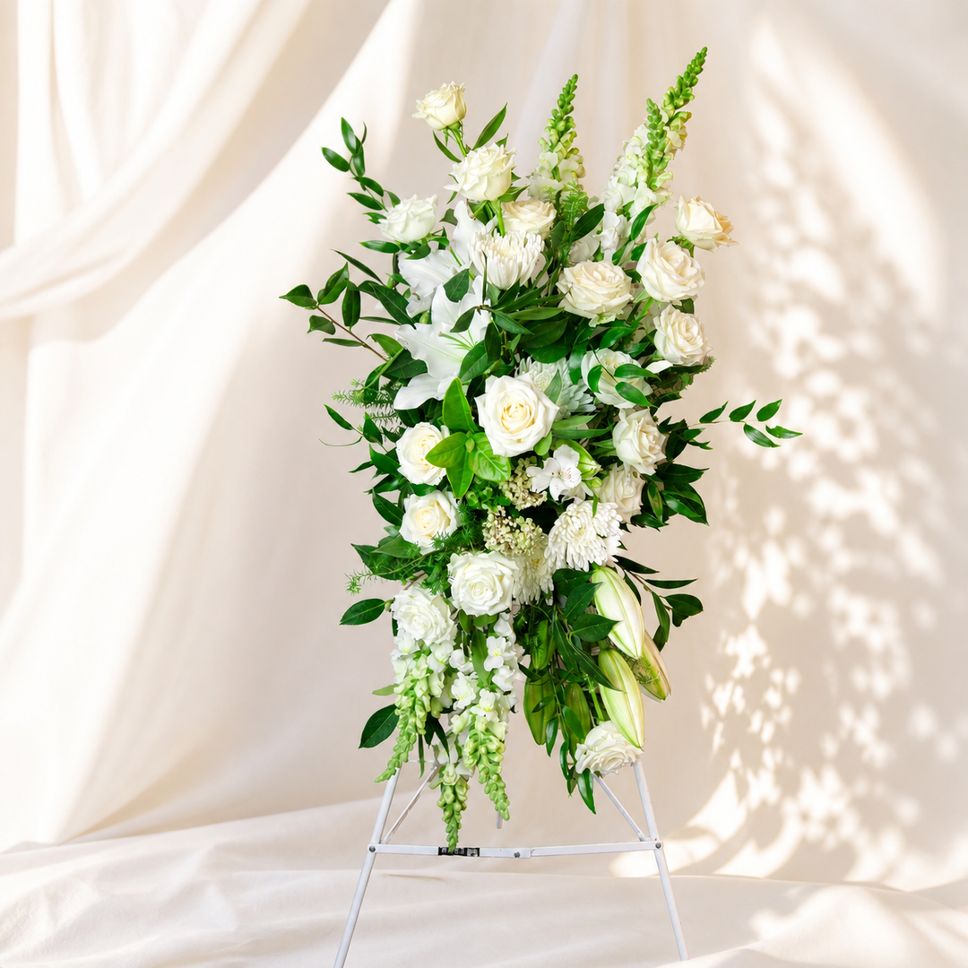 Classic white standing spray funeral flowers Melbourne with roses and greenery