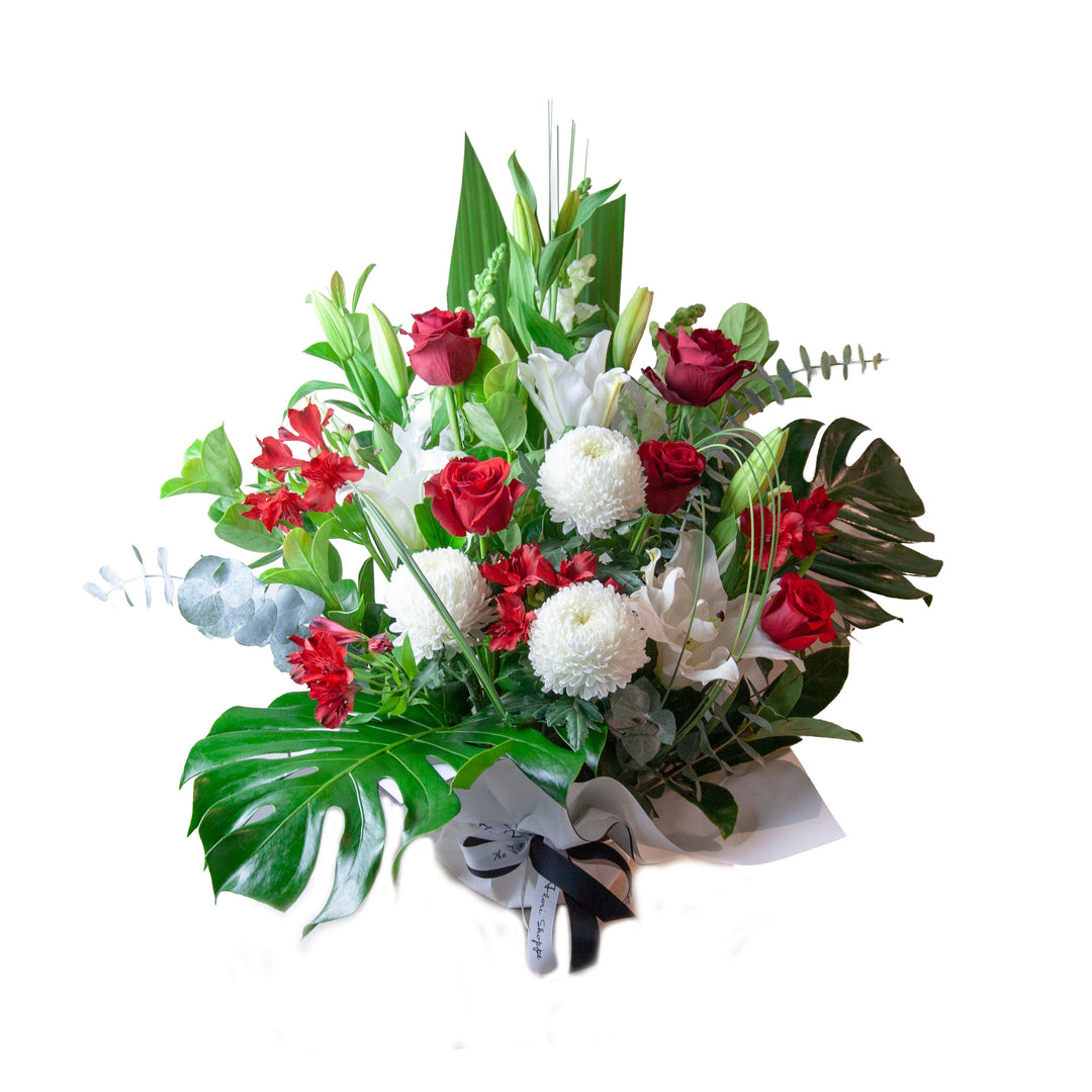 Grand Elegance premium bouquet featuring red roses, white lilies, white chrysanthemums and lush seasonal foliage.
