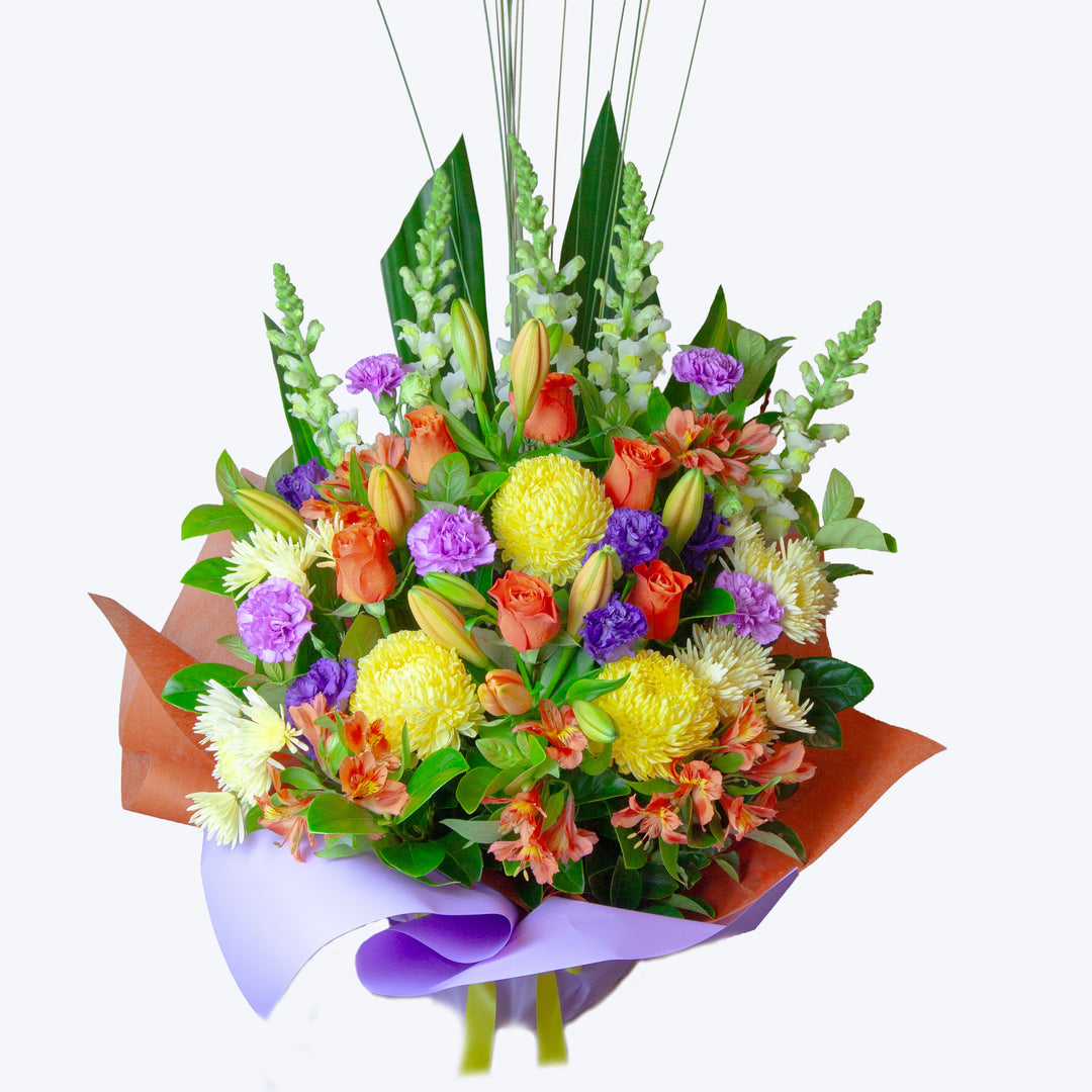 Sunshine Melody bouquet featuring orange roses, golden yellow chrysanthemums, lilies and vibrant seasonal flowers.