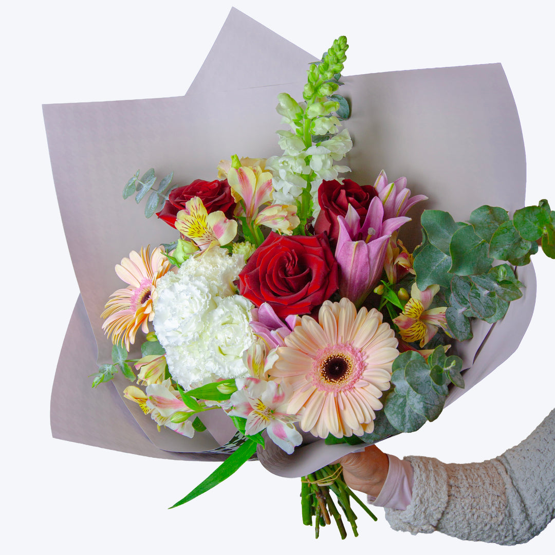 Sweet Blossom seasonal mixed bouquet featuring fresh pastel flowers and lush foliage.