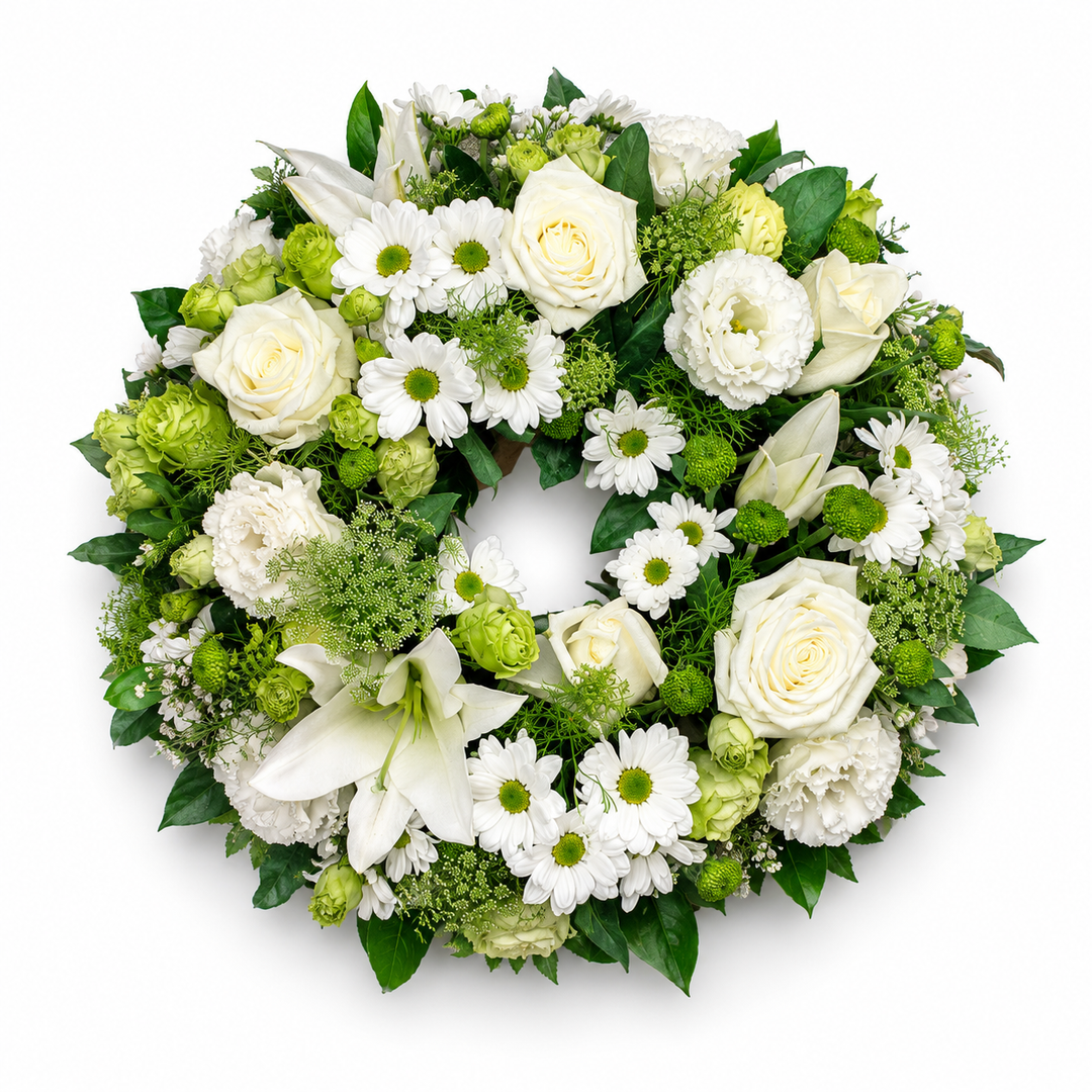 Evergreen Grace funeral wreath featuring white roses, lilies, chrysanthemums and fresh green foliage arranged in a classic circular tribute.