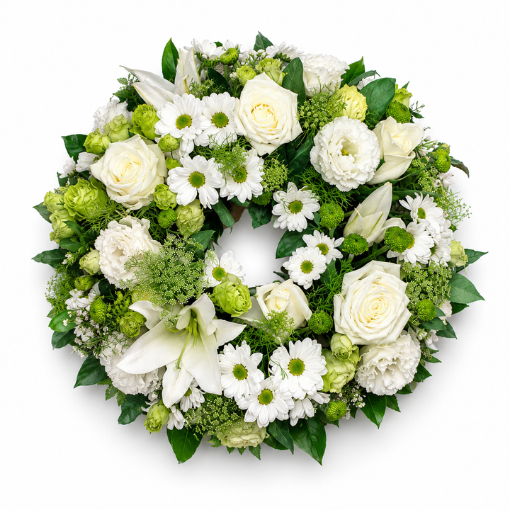 Evergreen Grace funeral wreath featuring white roses, lilies, chrysanthemums and fresh green foliage arranged in a classic circular tribute.