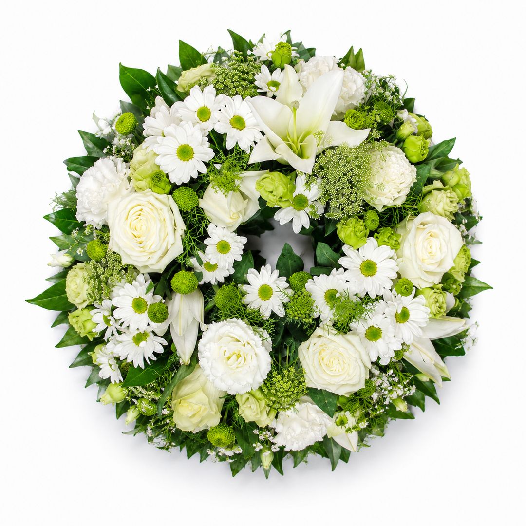 Evergreen Grace funeral wreath featuring white roses, lilies, chrysanthemums and fresh green foliage arranged in a classic circular tribute.