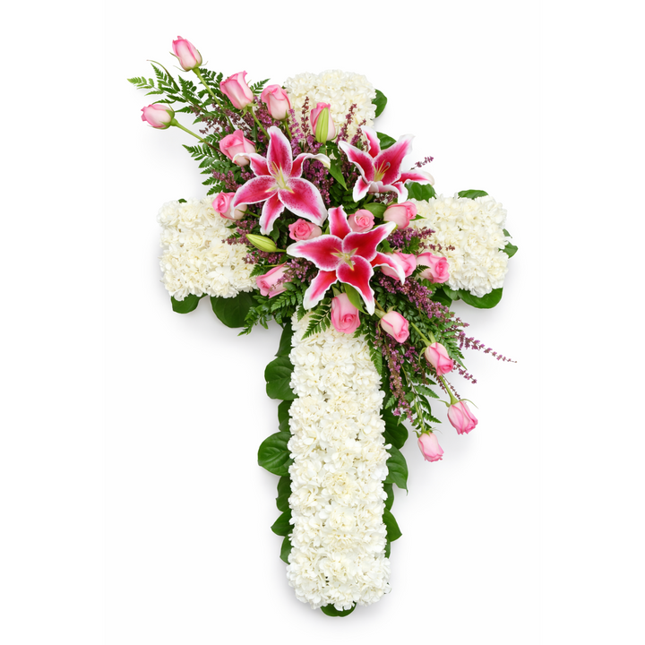 Floral arrangement in the shape of a cross with pink and white flowers on a white background