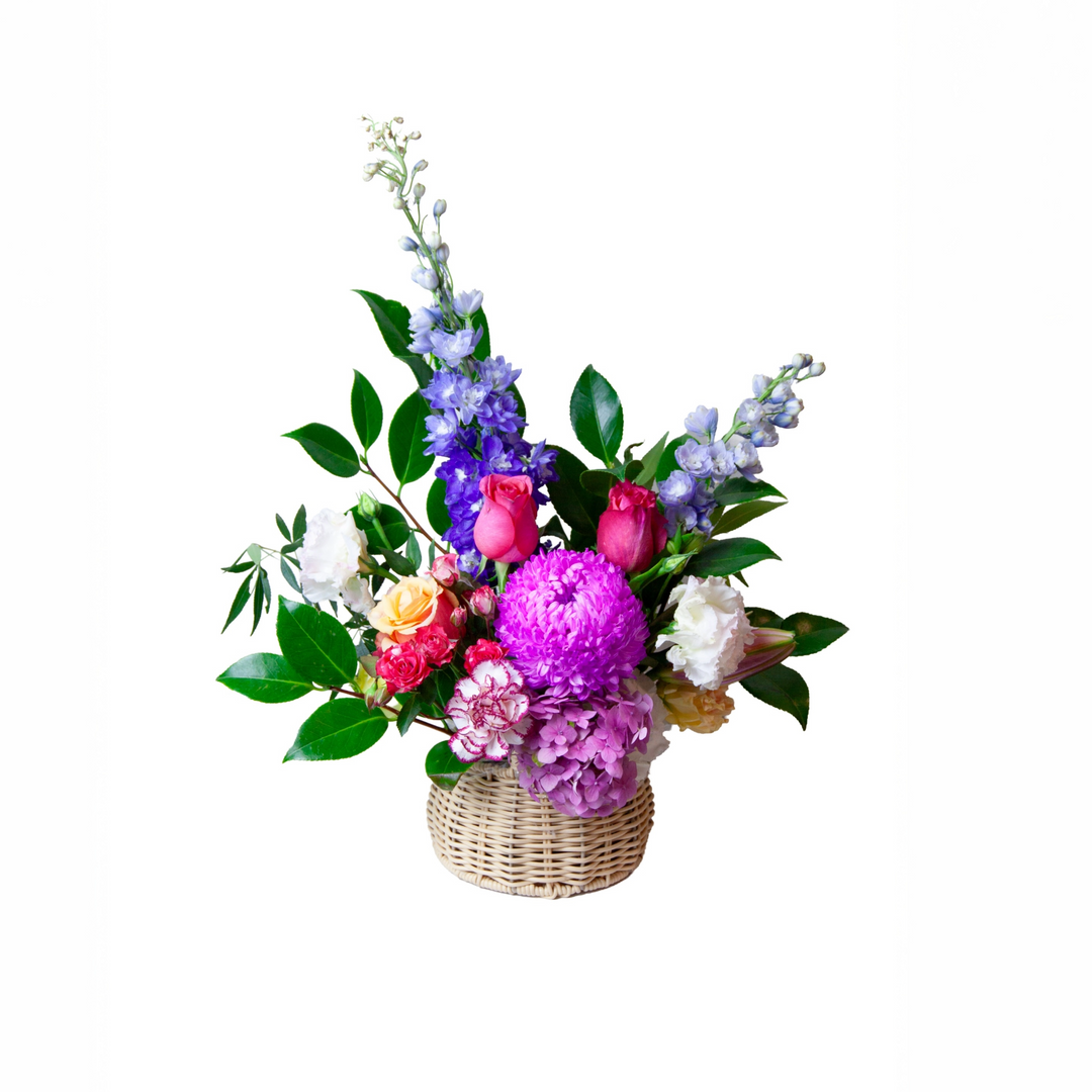 Wildflower Charm Melbourne flower basket arrangement with pink, purple and pastel seasonal blooms in a woven basket.