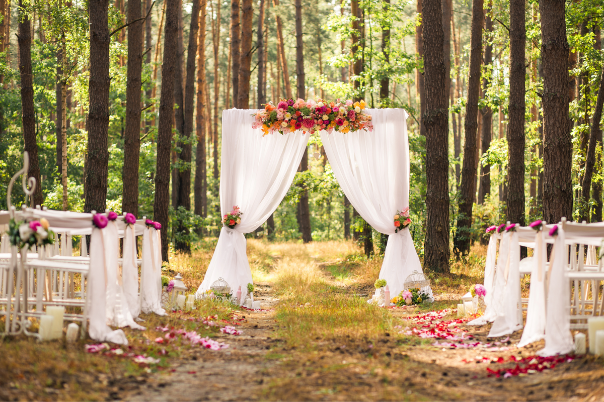 Decorated wedding arch with flowers and white curtains in a forest setting Wedding flowers Melbourne | The Floris Shoppe