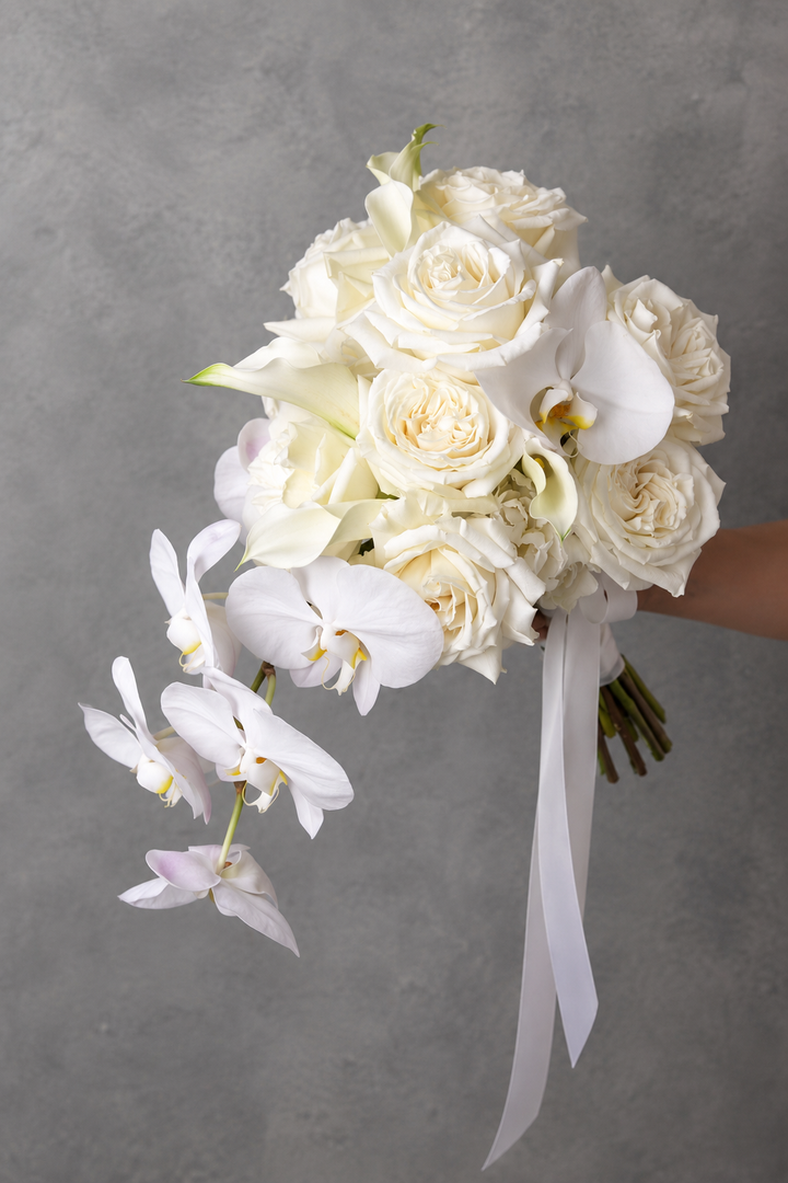Pure white cascading bridal bouquet with white Ecuadorian roses, calla lilies and Phalaenopsis orchids for a classic Melbourne wedding.