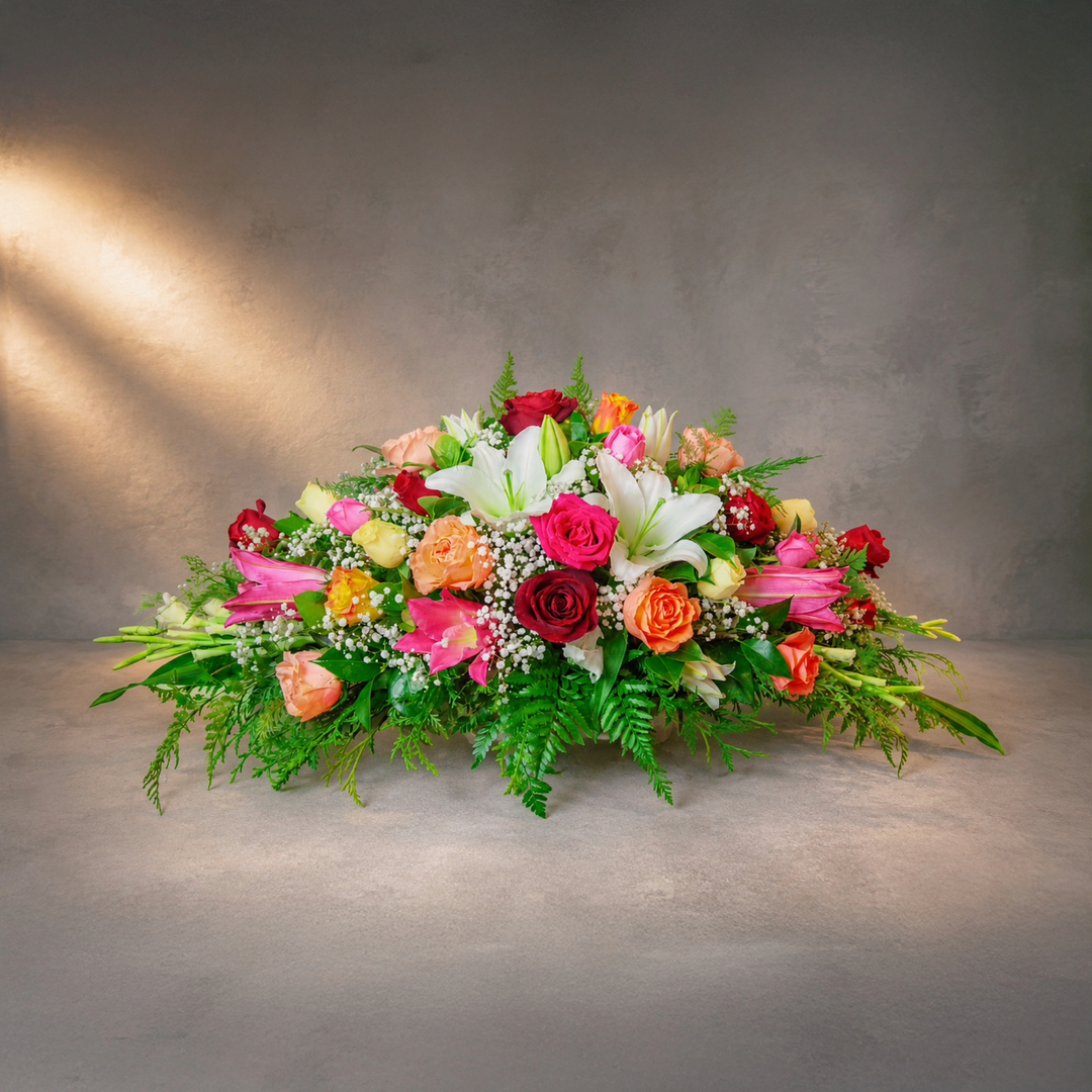 Somewhere Over the Rainbow colourful funeral casket spray with roses and lilies Melbourne